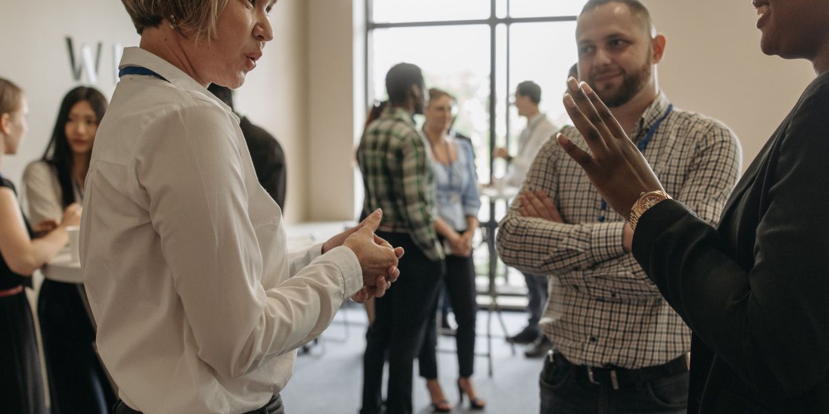 Professionals networking at an event, building crucial connections to access exclusive off-plan real estate opportunities.