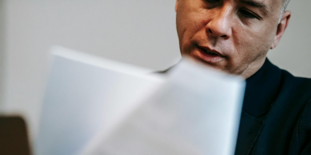 An individual focused on reviewing documents, emphasizing the importance of thorough due diligence in investments.