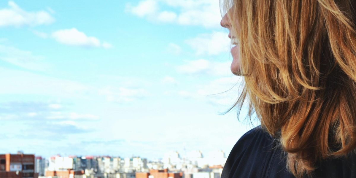 A person looks out over a modern city skyline, contemplating future investment opportunities and growth.