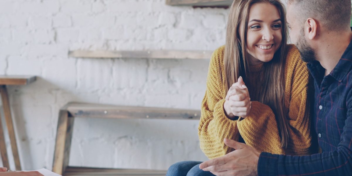 A couple engaging with a real estate agent, symbolizing the start of their luxury property search.