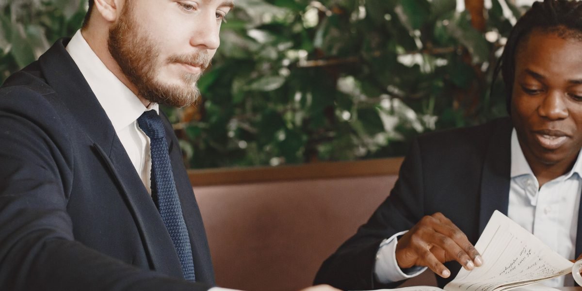 Two professionals engage in a serious discussion, likely analyzing potential risks and strategies for a property investment.