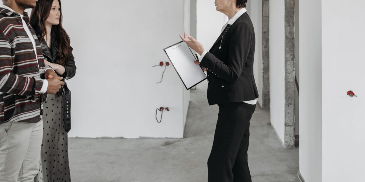 A client discusses luxury property options with a real estate agent in a modern office setting.