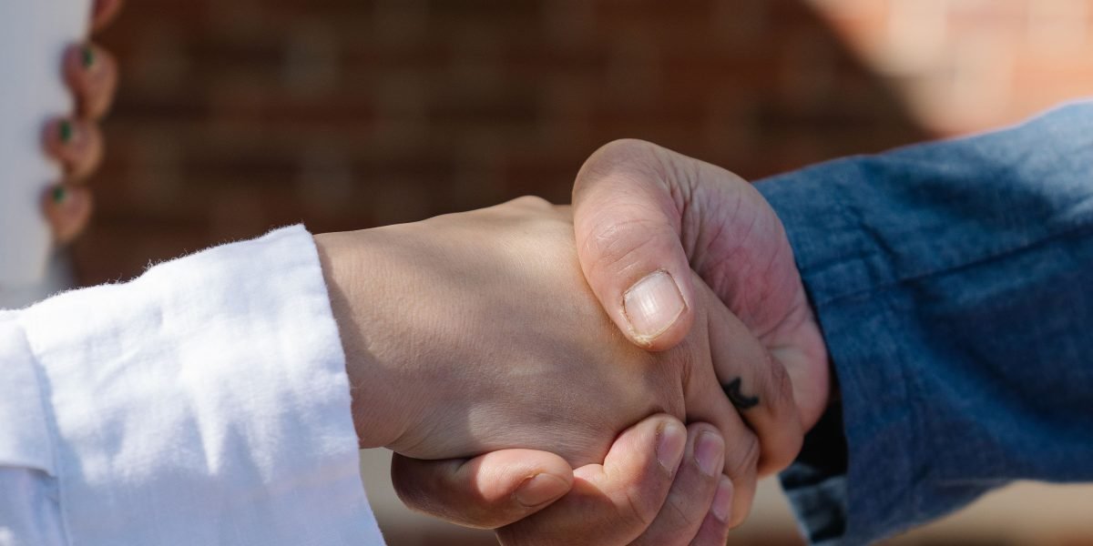 Professionals shaking hands, symbolizing a successful partnership and trusted service from a top real estate company.