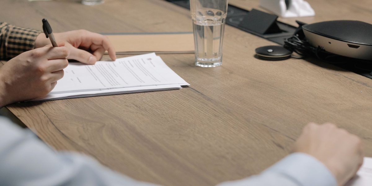 A professional signs legal documents, symbolizing the final, transparent steps of closing a property deal in Dubai.