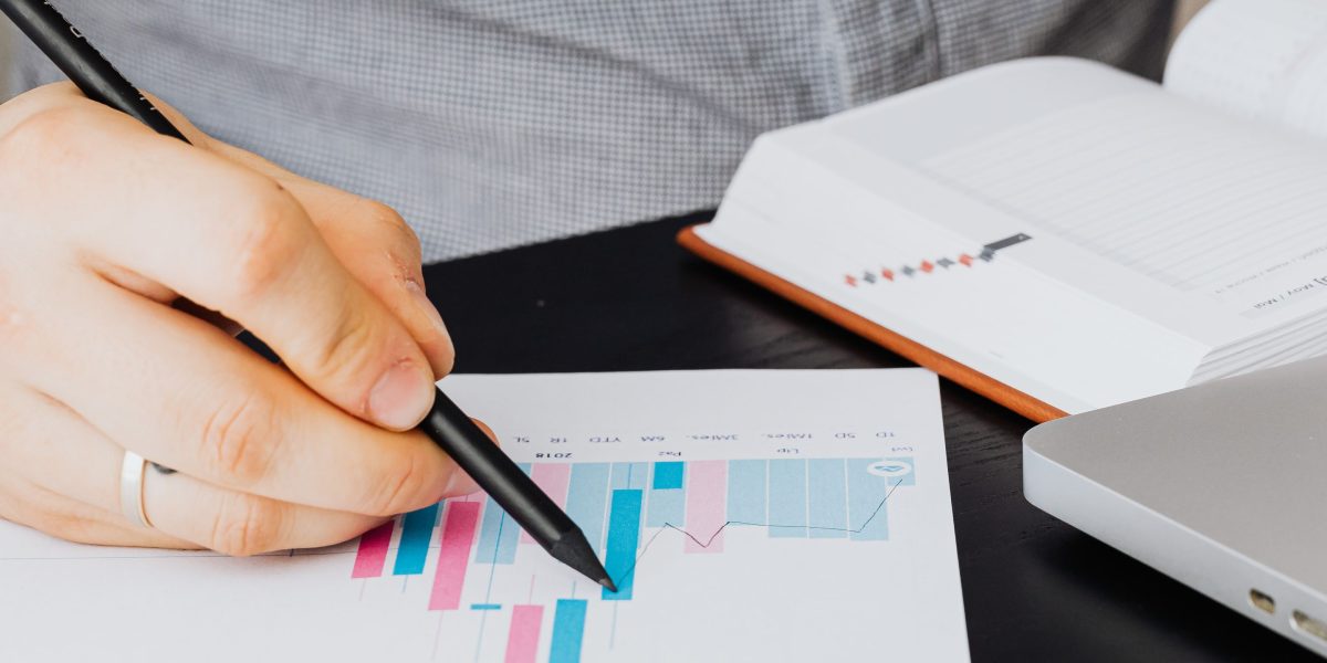 A person intently reviewing financial reports and investment charts, considering potential property returns.