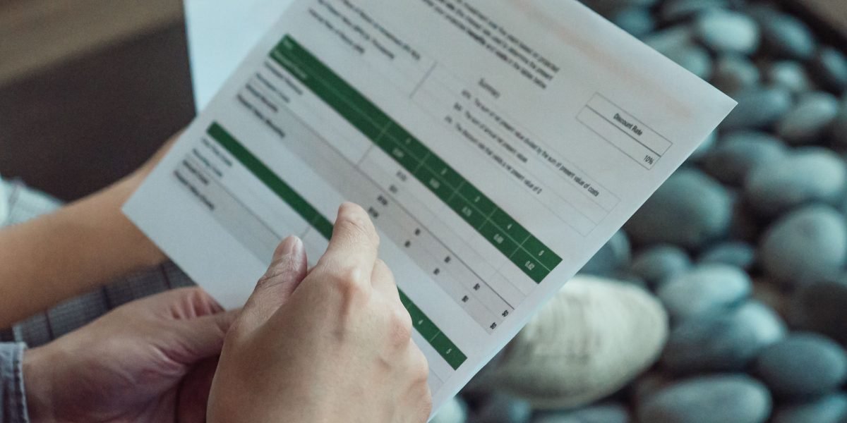 A person intently reviewing documents in a modern setting, symbolizing the research phase for high-net-worth investors.