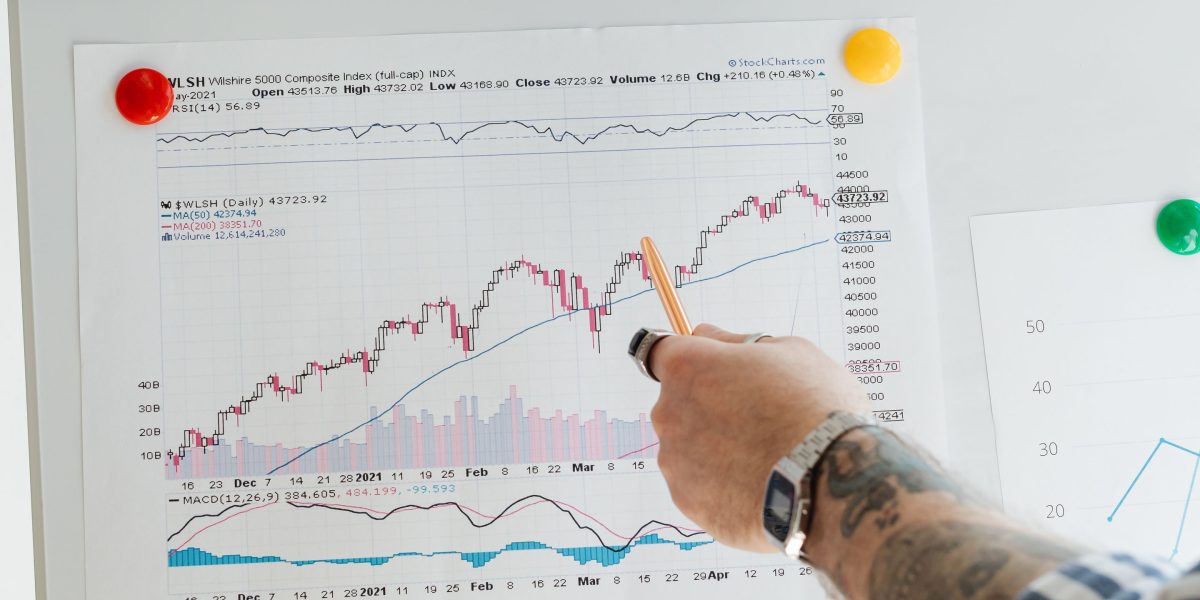 An investor reviewing financial market data on multiple screens, reflecting the analysis of Wasl's diverse holdings.