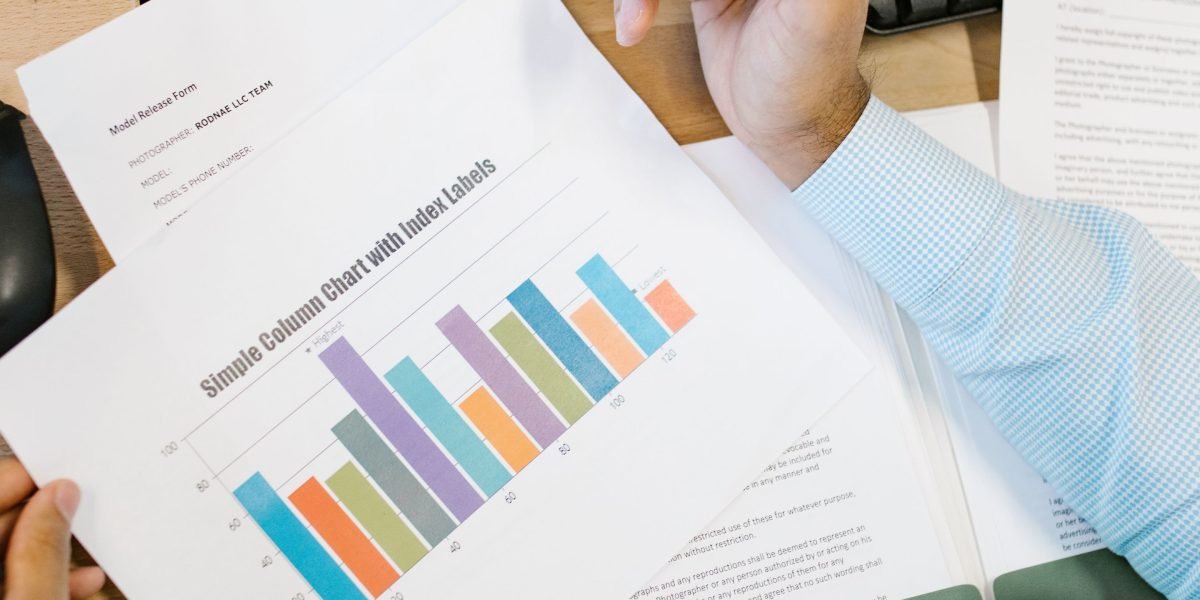 An investor diligently reviewing market reports and charts to grasp current real estate trends and make informed decisions.