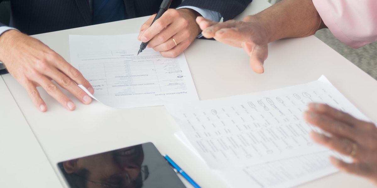 Professionals reviewing legal documents and discussing property details, representing expert guidance in the buying process.