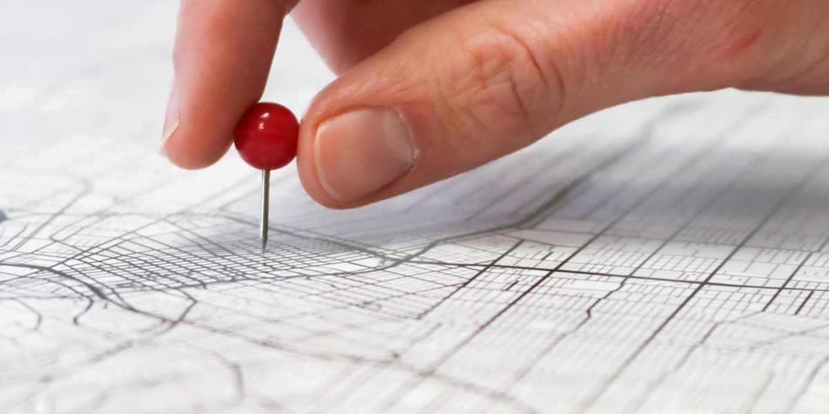An individual thoughtfully reviewing a map and notes, representing the meticulous planning involved in a significant property investment like Palm Jebel Ali.