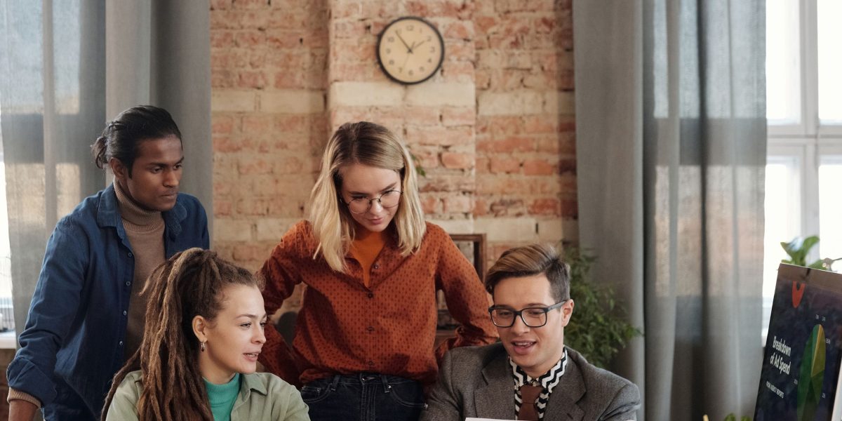 A group of professionals collaborating and reviewing documents, symbolizing the due diligence and vetting process for selecting a luxury brokerage.