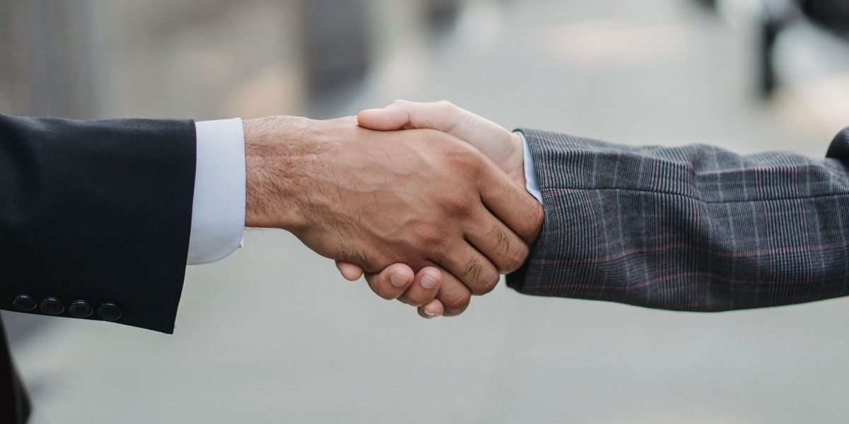 Two business professionals shaking hands after reaching a successful agreement, signifying a smart investment choice.