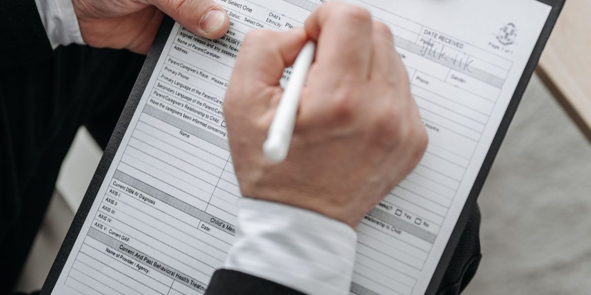 A professional reviews and signs legal documents, an essential step in securing property ownership.