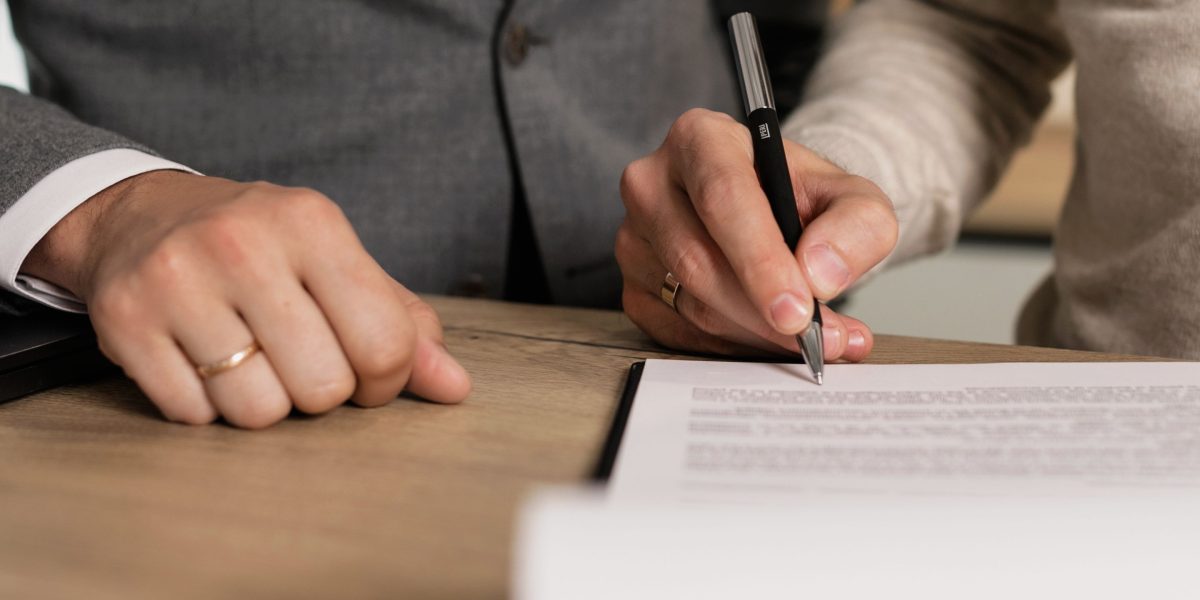 Business partners or investors signing legal documents, representing a property transaction in Dubai.
