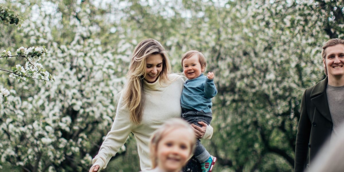 A family enjoying a leisurely stroll in a beautifully landscaped, family-friendly community park.